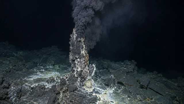 暗い海底の鉱物チムニーから黒い粒子を含む流体が上昇する熱水噴出孔の再構成