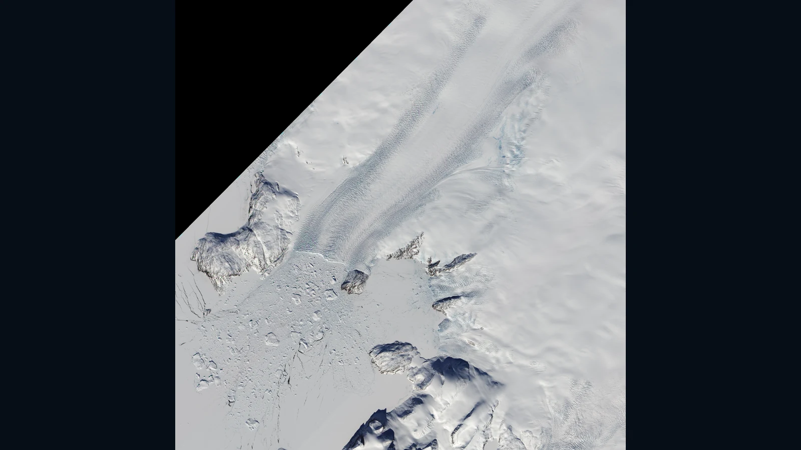 グリーンランドのコング・オスカー氷河の割れ目の多い末端と、沖の氷の集まりを写す衛星画像