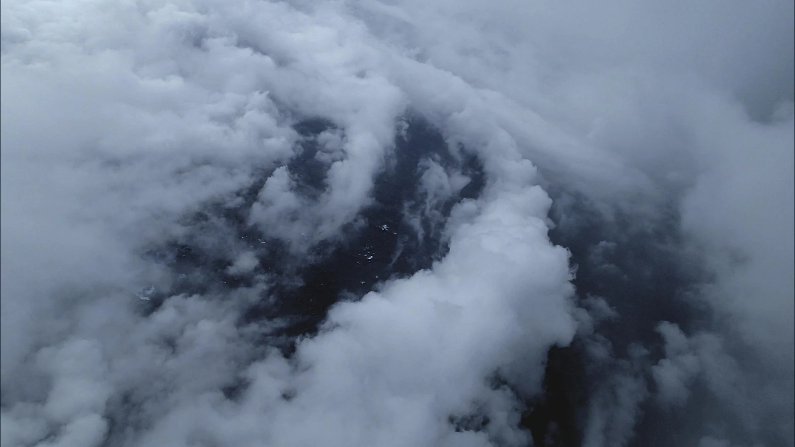 ハリケーンEdouardの目の中で、海面の上に帯状に分布する低い雲を航空機から見た写真