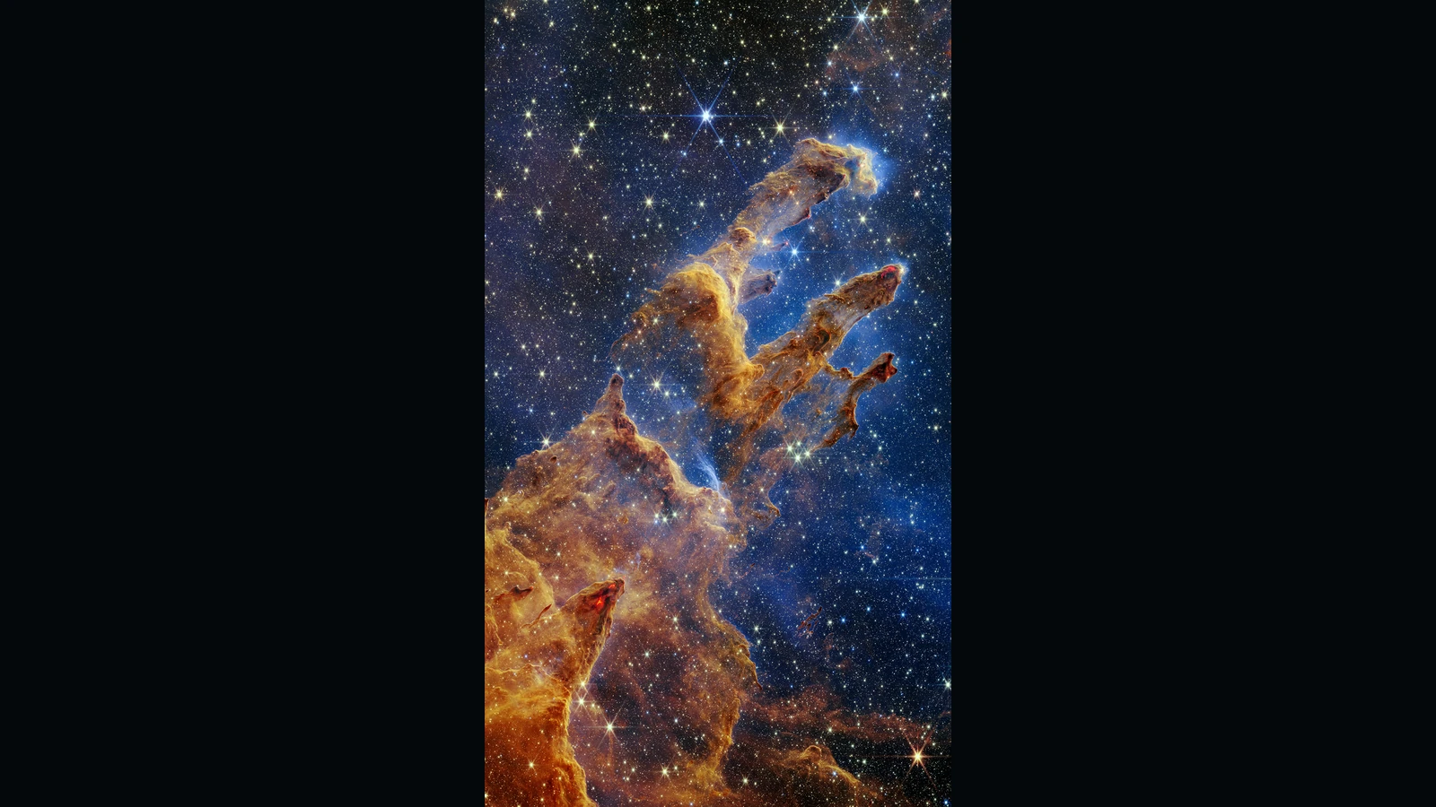多数の星を背景に、褐色と金色で表示されたガスと塵の柱が斜めに伸びる